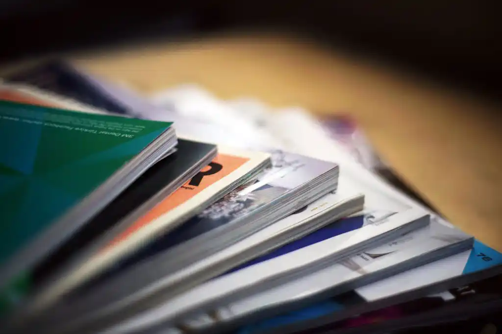 Pile de brochures colorées posées en éventail sur une table.